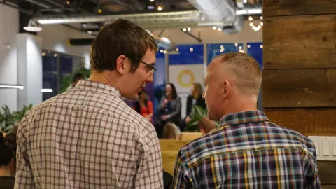 Two teammates chatting at an office event