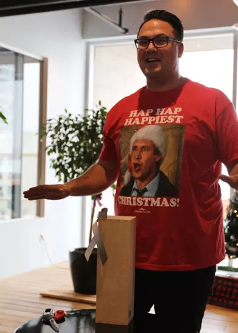 A teammate in a holiday t-shirt addressing the office