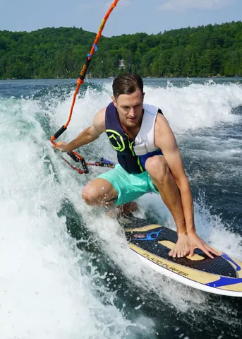 A teammate wakeboarding on a lake
